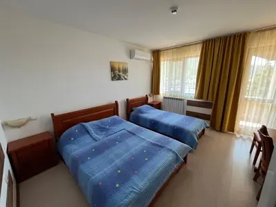 two beds in a bedroom with blue sheets at Centaur Family Hotel in Rila