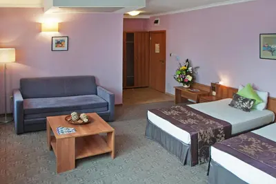 a hotel room with two beds and a couch at Hotel Real in Plovdiv