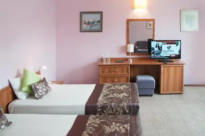 a hotel room with a bed and a desk with a television at Hotel Real in Plovdiv