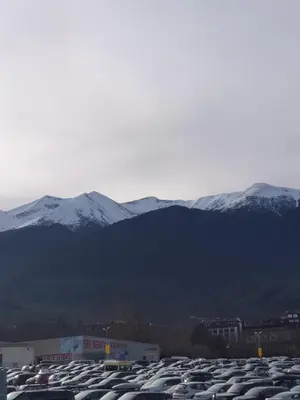 a parking lot with snow covered mountains in the background at Dream Apart Hotel 207 in Bansko