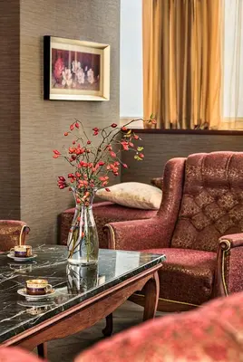 a vase with flowers on a table in a living room at Park Hotel Moskva in Sofia