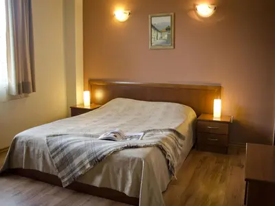 a bedroom with a bed with two night stands and two lamps at Bizev Hotel in Bansko