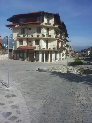 a building on a street with a stop sign in front of it at Hotel Gazei in Bansko