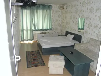 a bedroom with a bed and a couch and a table at Hotel Pilevski in Blagoevgrad