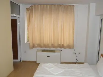 a bedroom with a white bed and a window at Hotel Pilevski in Blagoevgrad