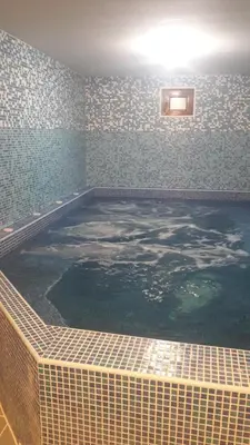 a large swimming pool in a room with a tile wall at Guest House Todorini kashti in Koprivshtitsa