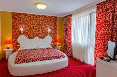 a bedroom with a bed with red and yellow walls at Hotel Park Bachinovo in Blagoevgrad