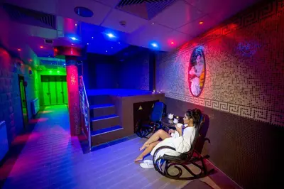 a woman sitting in a chair in a room at Hotel Park Bachinovo in Blagoevgrad
