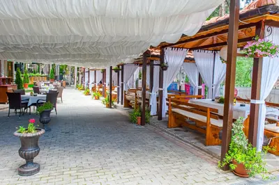 a patio of a restaurant with tables and chairs at Hotel Park Bachinovo in Blagoevgrad