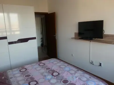 a small bedroom with a bed and a flat screen tv at Belveder Holiday Club Private in Bansko