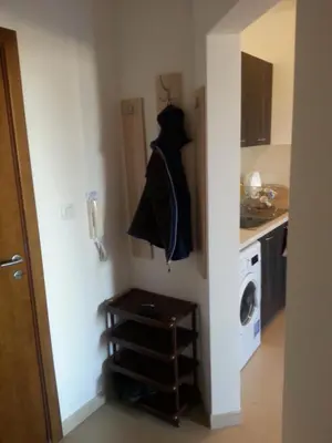 a small kitchen with a washing machine and a door at Belveder Holiday Club Private in Bansko