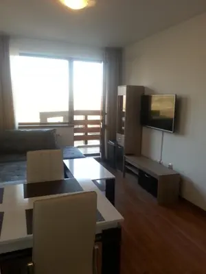 a living room with a couch and a flat screen tv at Belveder Holiday Club Private in Bansko