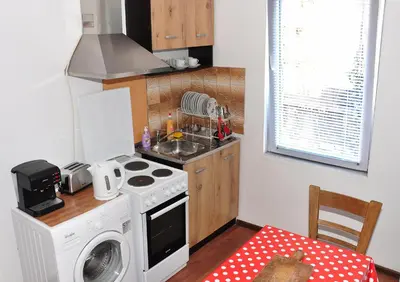 a small kitchen with a stove and a washing machine at Ayki - historic centre apartment in Sofia