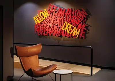 a chair in front of a piece of art at Rila Hotel Sofia in Sofia