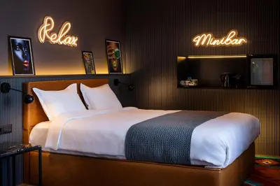 a bedroom with a large bed and neon signs at Rila Hotel Sofia in Sofia