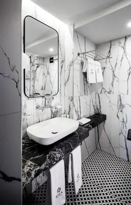 a black and white bathroom with a sink and a mirror at Rila Hotel Sofia in Sofia
