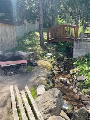 a wooden bridge and a bench in a yard at Вила Мерджан in Sarnitsa