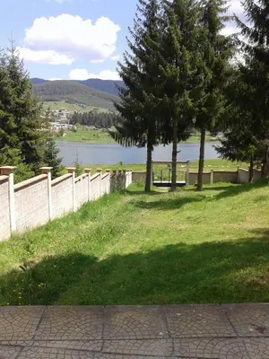 a field with trees and a fence and a body of water at Вила Мерджан in Sarnitsa
