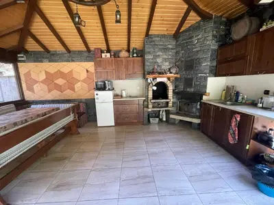 a kitchen with a stone fireplace and a stove at Вила Мерджан in Sarnitsa