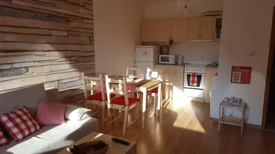 a living room with a couch and a table and a kitchen at Papa Moose Pamporovo in Pamporovo