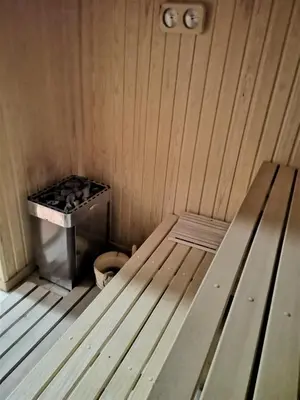 a wooden bench in a sauna with a stove at Papa Moose Pamporovo in Pamporovo