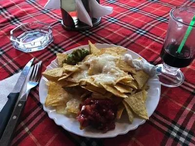 a plate of food with nachos on a table at Flora Ski-slope Studio Apartment in Borovets
