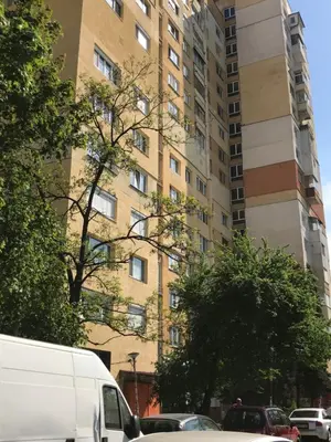 a tall building with cars parked in front of it at Modern Studio 20 Meters from Mladost 1 Metro Station in Sofia