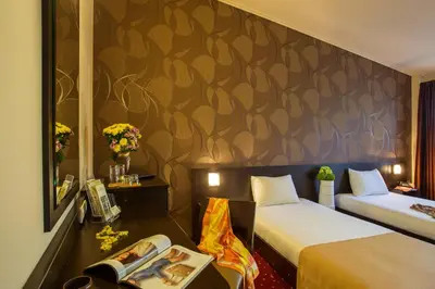 a hotel room with two beds and a wall with a mural at Hotel Villa Boyana - Free Parking in Sofia