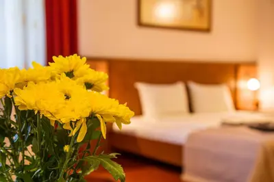 a vase of yellow flowers in a hotel room at Hotel Villa Boyana - Free Parking in Sofia