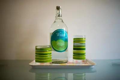 a bottle of water on a tray with two stacks of coins at City Apartments in Sofia