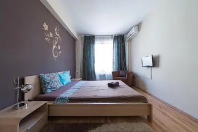 a bedroom with a large bed and a window at City Apartments in Sofia