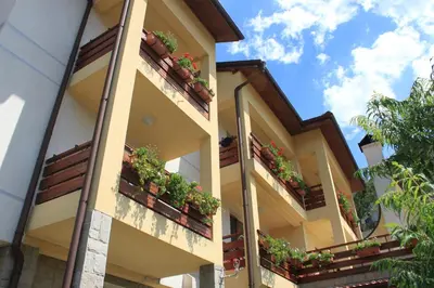 an apartment building with potted plants on the balconies at Kris Guest House in Devin
