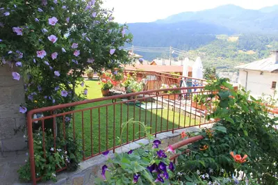 a balcony with purple flowers and a fence at Kris Guest House in Devin