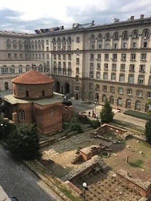 a large building with a courtyard in front of it at Apartment Rotonda in Sofia