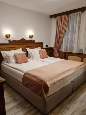 a bedroom with two beds and a window at Chuchura Family Hotel in Koprivshtitsa