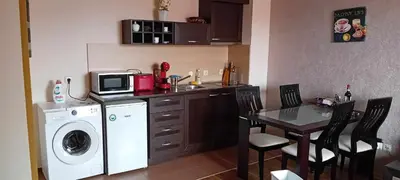 a kitchen with a washing machine and a table with chairs at Katy's studio in Bansko