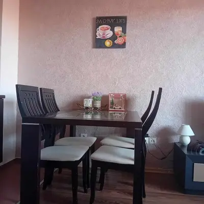 a dining room table with chairs and a picture on the wall at Katy's studio in Bansko