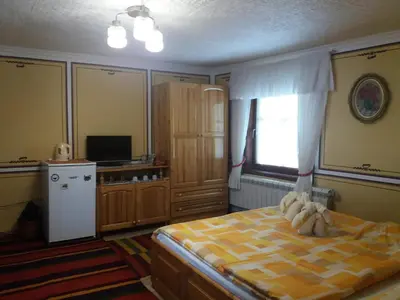 a bedroom with a bed and a television and a window at Guest Rooms Bashtina Striaha in Koprivshtitsa