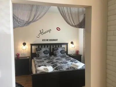 a bedroom with a bed with a sign that reads kiss me comfort at Panorama Apartment Darvenitsa in Sofia