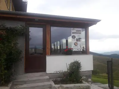 a building with a door and a sign in the window at Къща за гости Чала in Chala