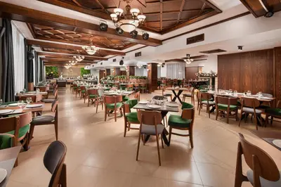 a restaurant with tables and chairs in a room at Alfaresort Palace Chiflika in Chiflik