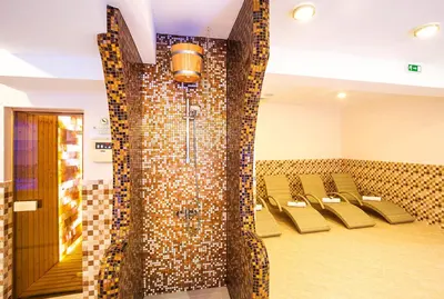 a dining room with chairs and a wall of mosaic tiles at Family Hotel Romantika in Velingrad