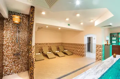 a large room with a pool and chairs at Family Hotel Romantika in Velingrad