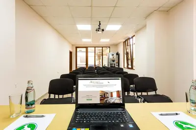 a conference room with a laptop on a table with chairs at Family Hotel Romantika in Velingrad