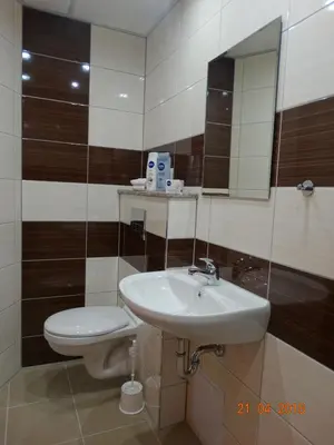 a bathroom with a sink and a toilet and a mirror at Hotel Lago Peshtera in Peshtera