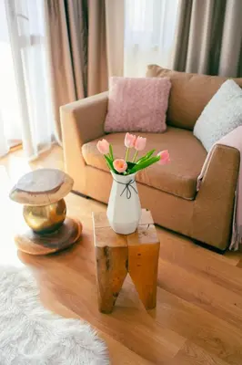 a vase with pink flowers sitting on a table in a living room at Rodope Nook Guest house in Chepelare