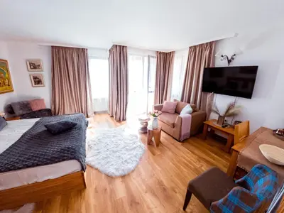 a living room with a bed and a couch at Rodope Nook Guest house in Chepelare