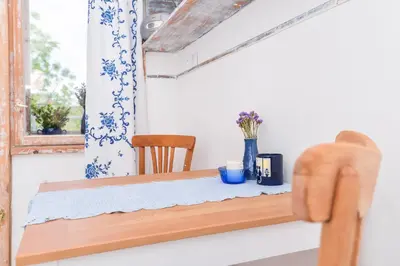 a dining room table with a blue and white curtain at Shik & Chic One Bedroom Central Apartment Graf Ignatiev x Shishman Corner by Flat Mаnager in Sofia