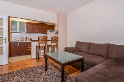 a living room with a couch and a table and a kitchen at Comfortable One Bedroom Apartment in a Lively Area | Zona B5 | Russian Square in Sofia