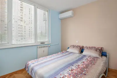 a bed in a room with blue walls and windows at Comfortable One Bedroom Apartment in a Lively Area | Zona B5 | Russian Square in Sofia